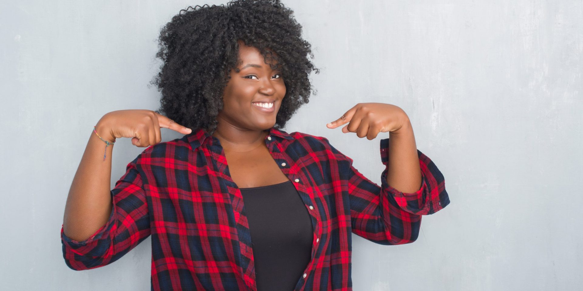 Woman in plaid pointing to herself
