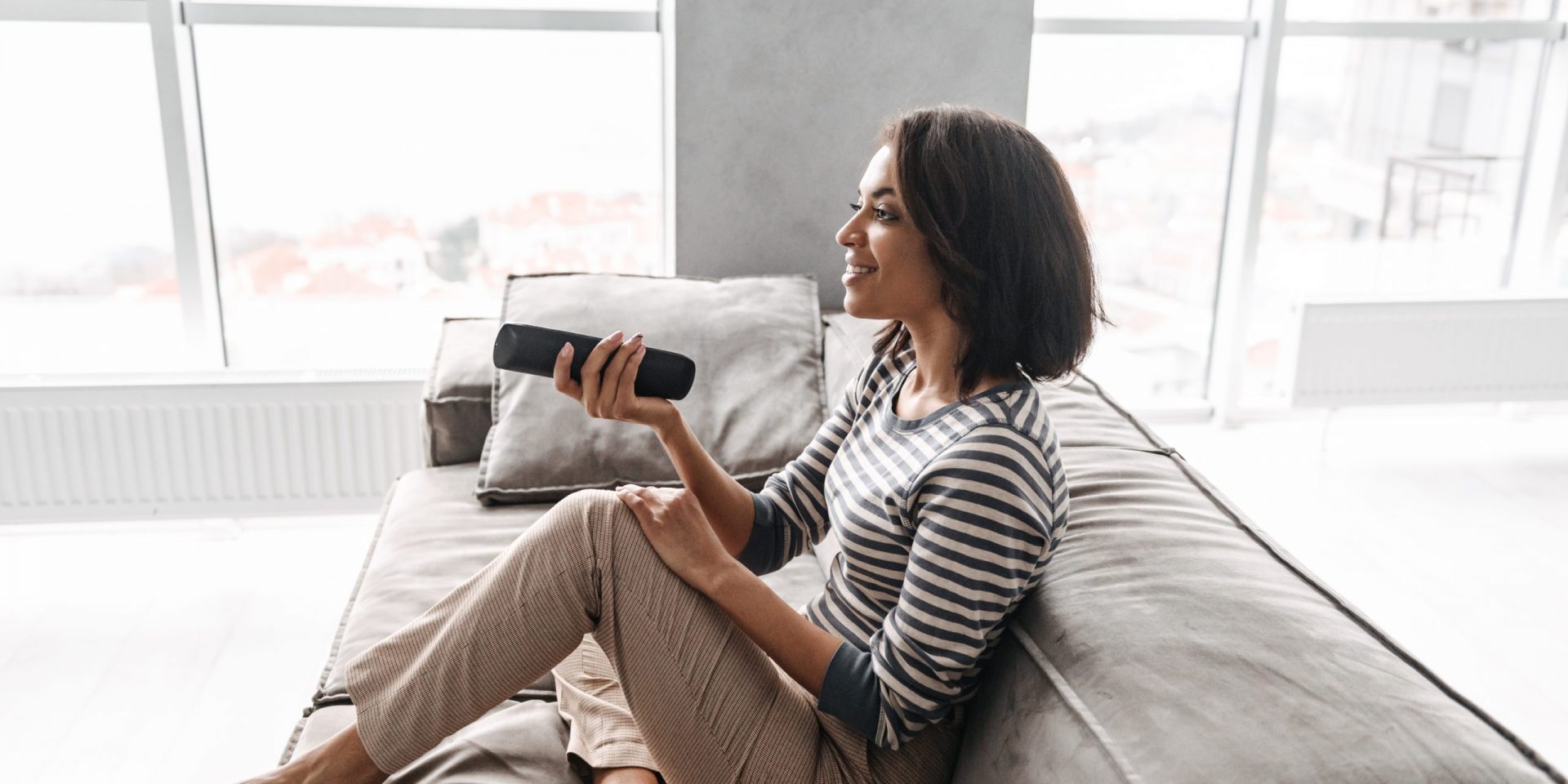 Woman on the couch with feet up watching TV