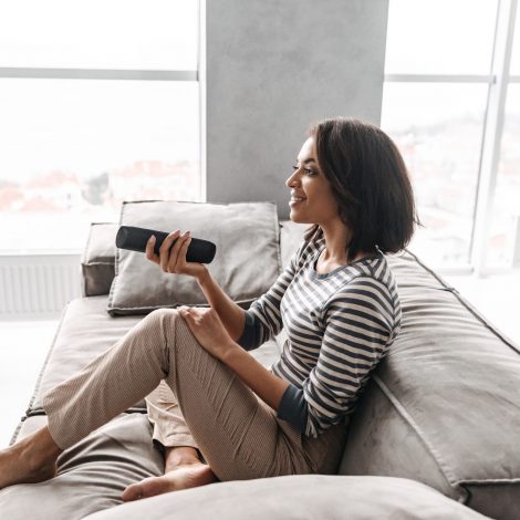 Woman on the couch with feet up watching TV