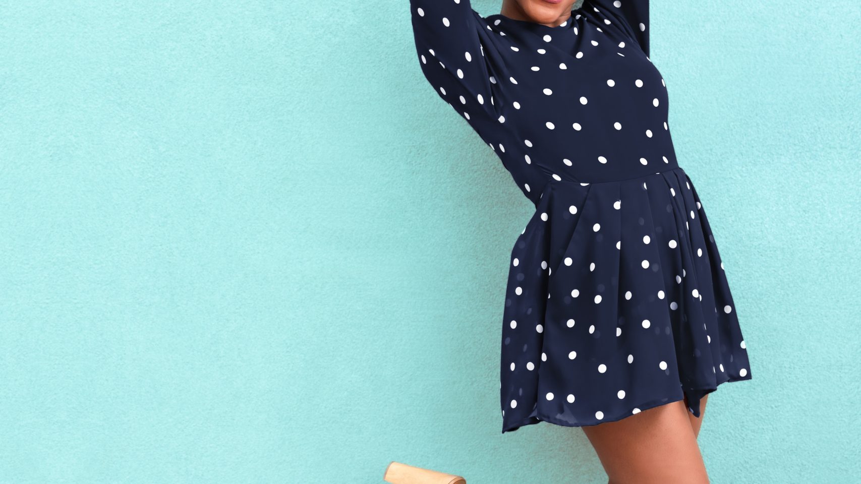 Woman with hand in the air in front of a blue background