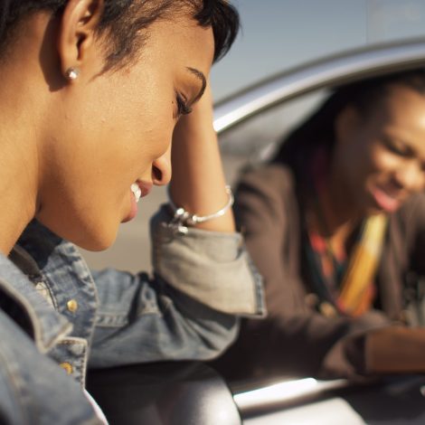Woman standing next to car