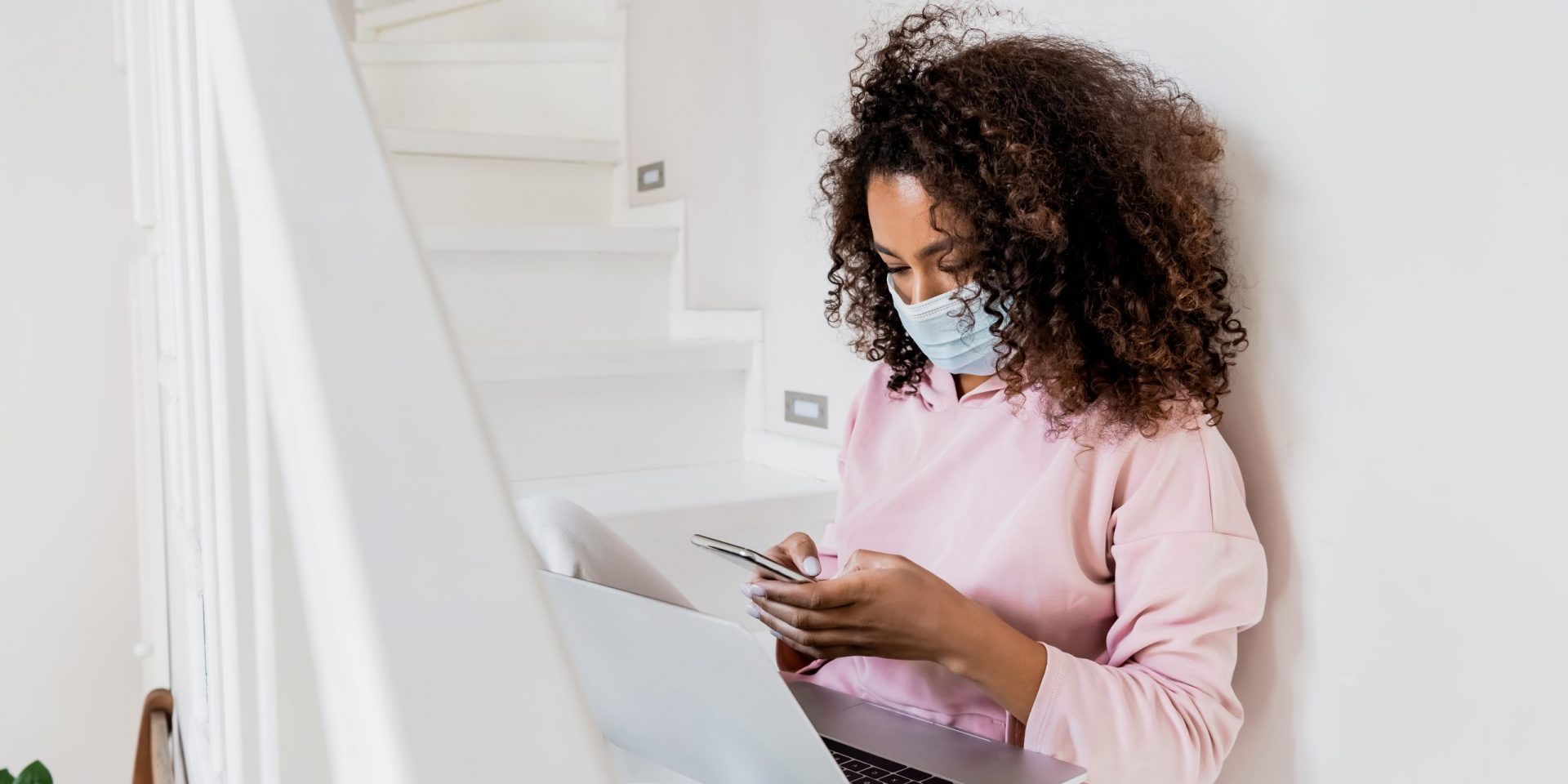 Woman with a face mask on her computer