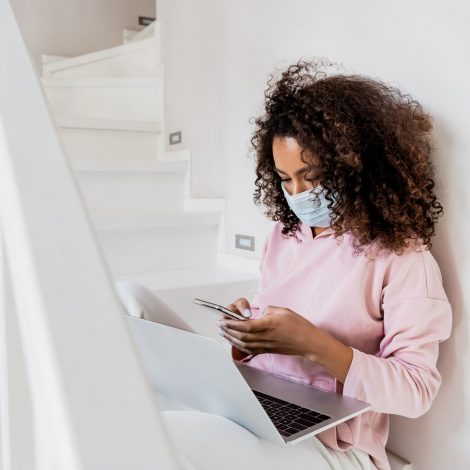 Woman with a face mask on her computer