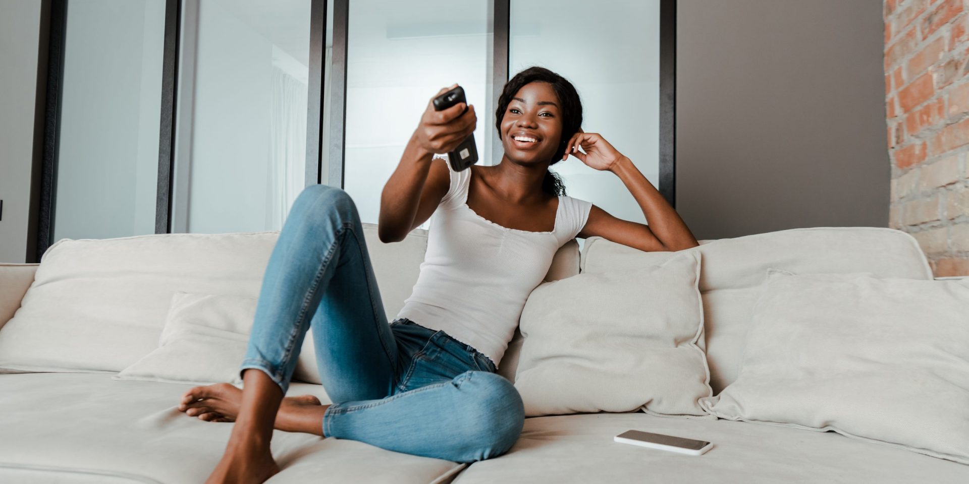 Woman watching TV with a remote control in her hands