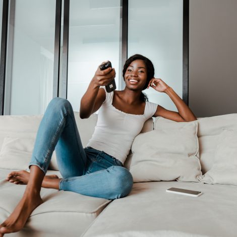 Woman watching TV with a remote control in her hands