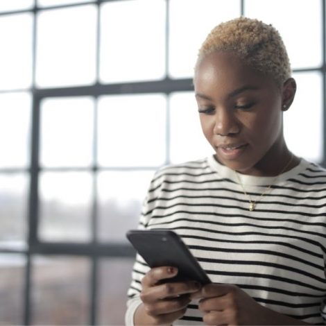 Woman in front of a window looking at her phone