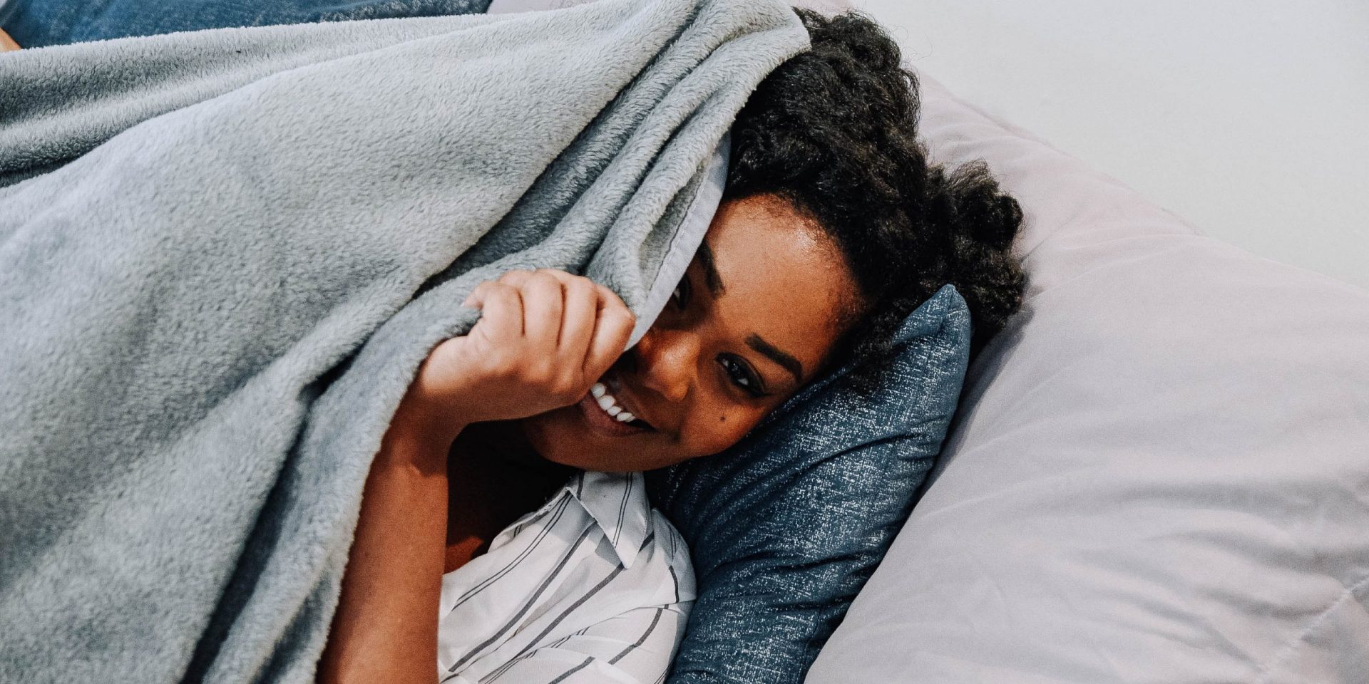 Woman peaking underneath blanket