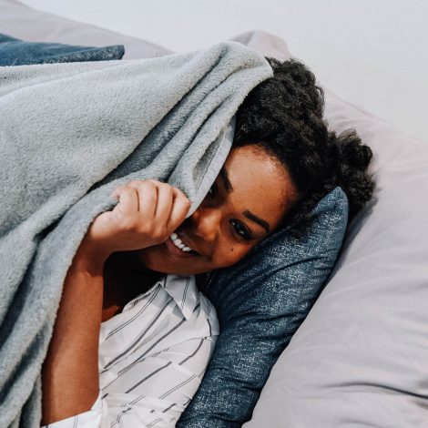 Woman peaking underneath blanket