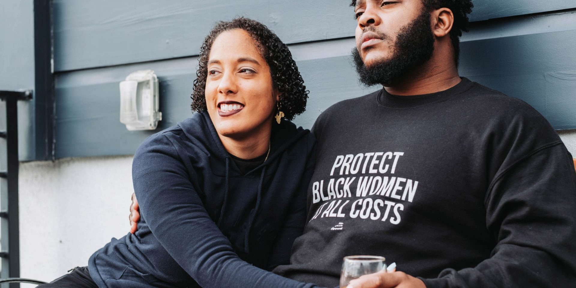 Man and woman sitting next to house