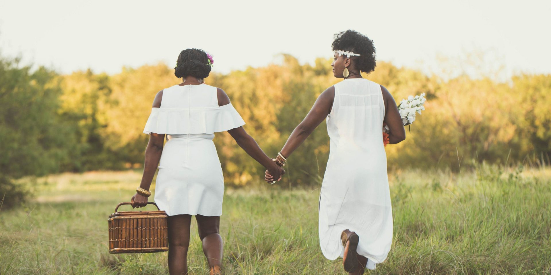 Two women holding hands outside