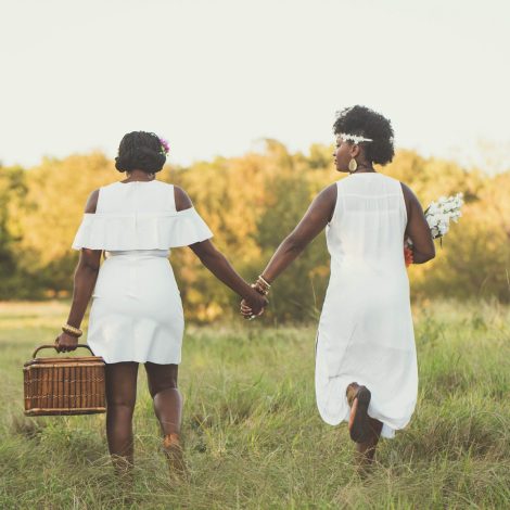 Two women holding hands outside