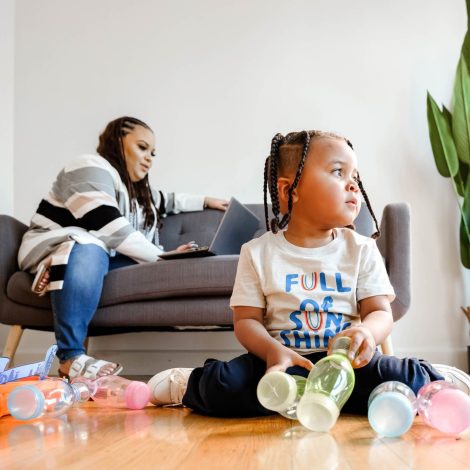 Woman on coach while baby plays with toys