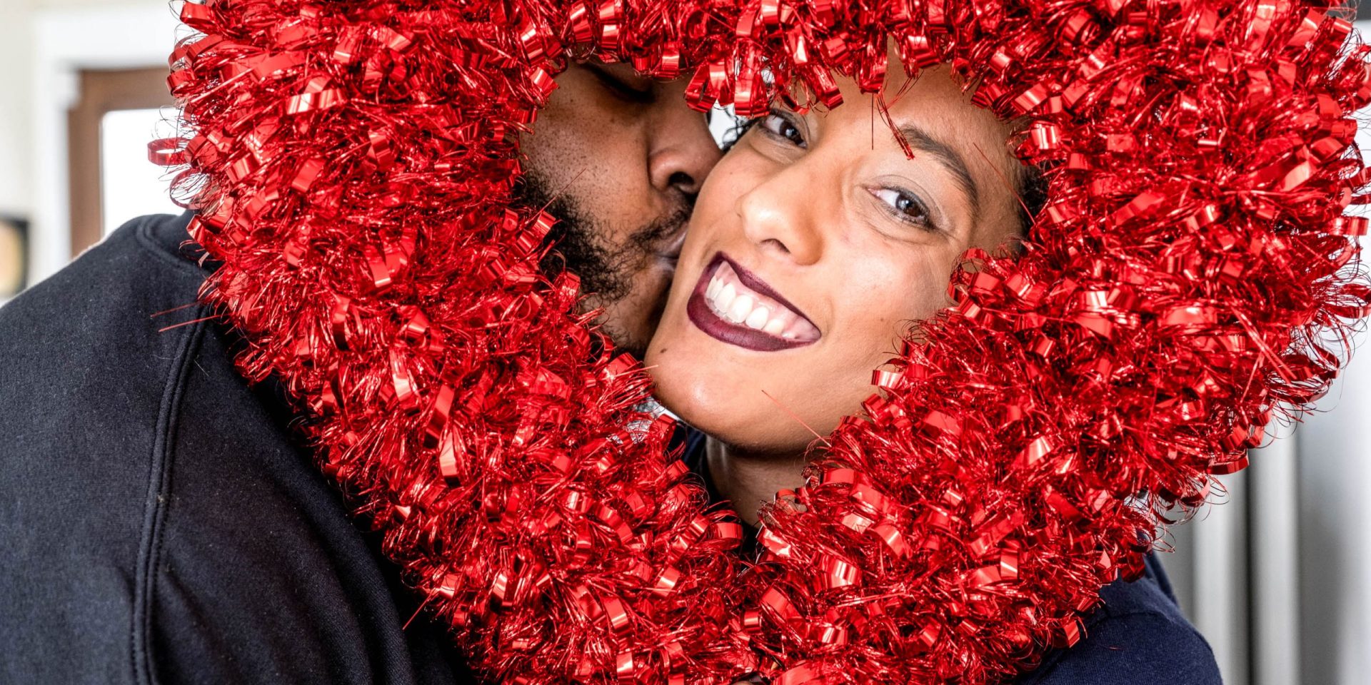 Couple smiling behind heart