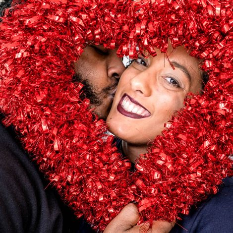 Couple smiling behind heart